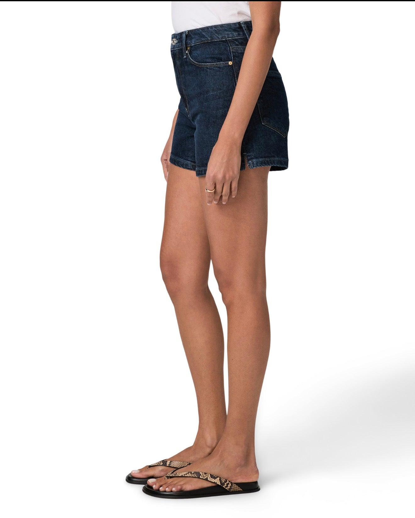 Person wearing dark blue denim shorts on a white background