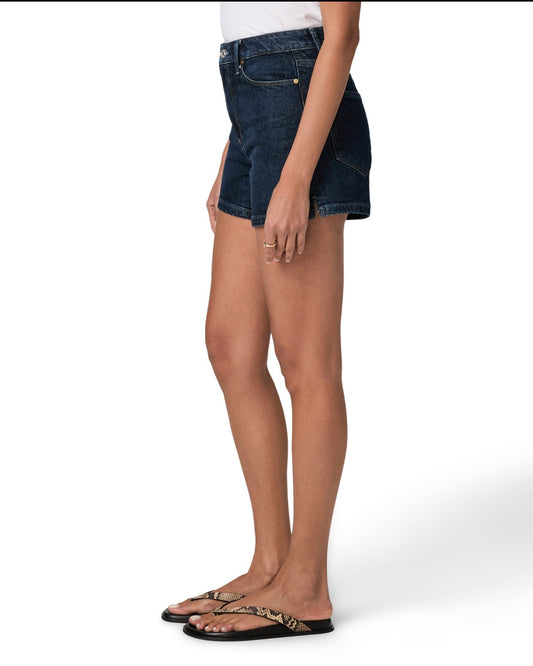 Person wearing dark blue denim shorts on a white background