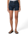 Person wearing dark blue denim shorts on a white background