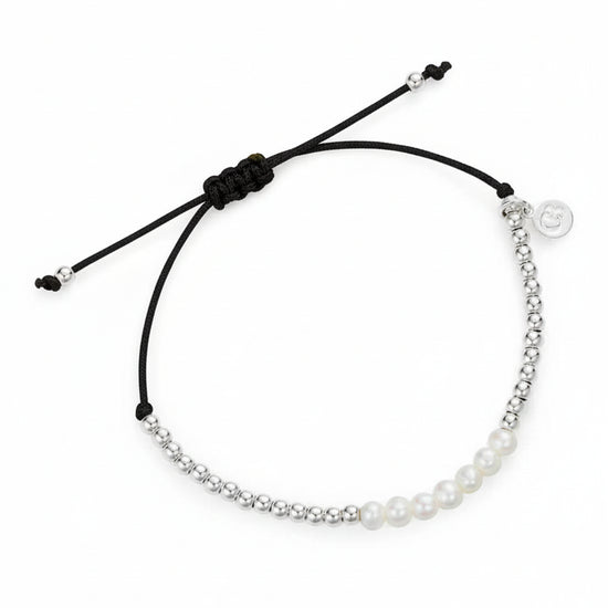 Bracelet with pearls and a black cord on a white background