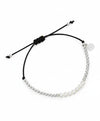 Bracelet with pearls and a black cord on a white background