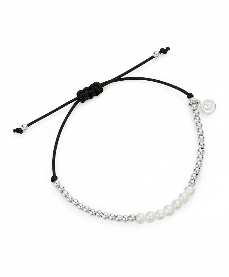 Bracelet with pearls and a black cord on a white background