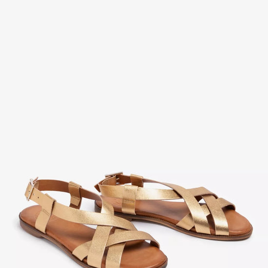 Pair of gold sandals on a white background