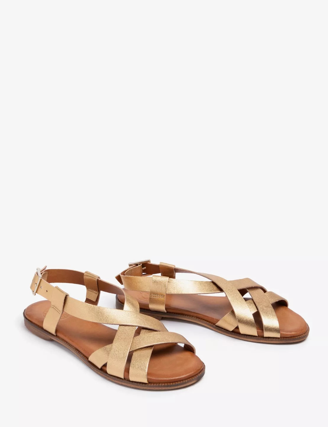 Pair of gold sandals on a white background