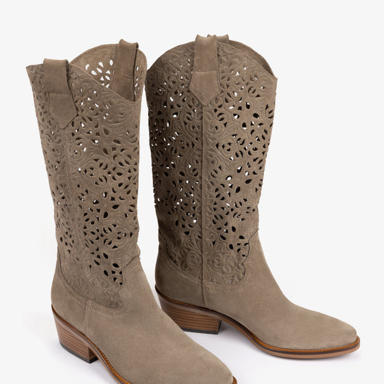 Pair of beige cowboy boots with perforated design on a white background from Penelope Chilvers