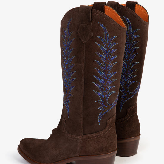 Two Brown cowboy boots with blue embroidery on white background