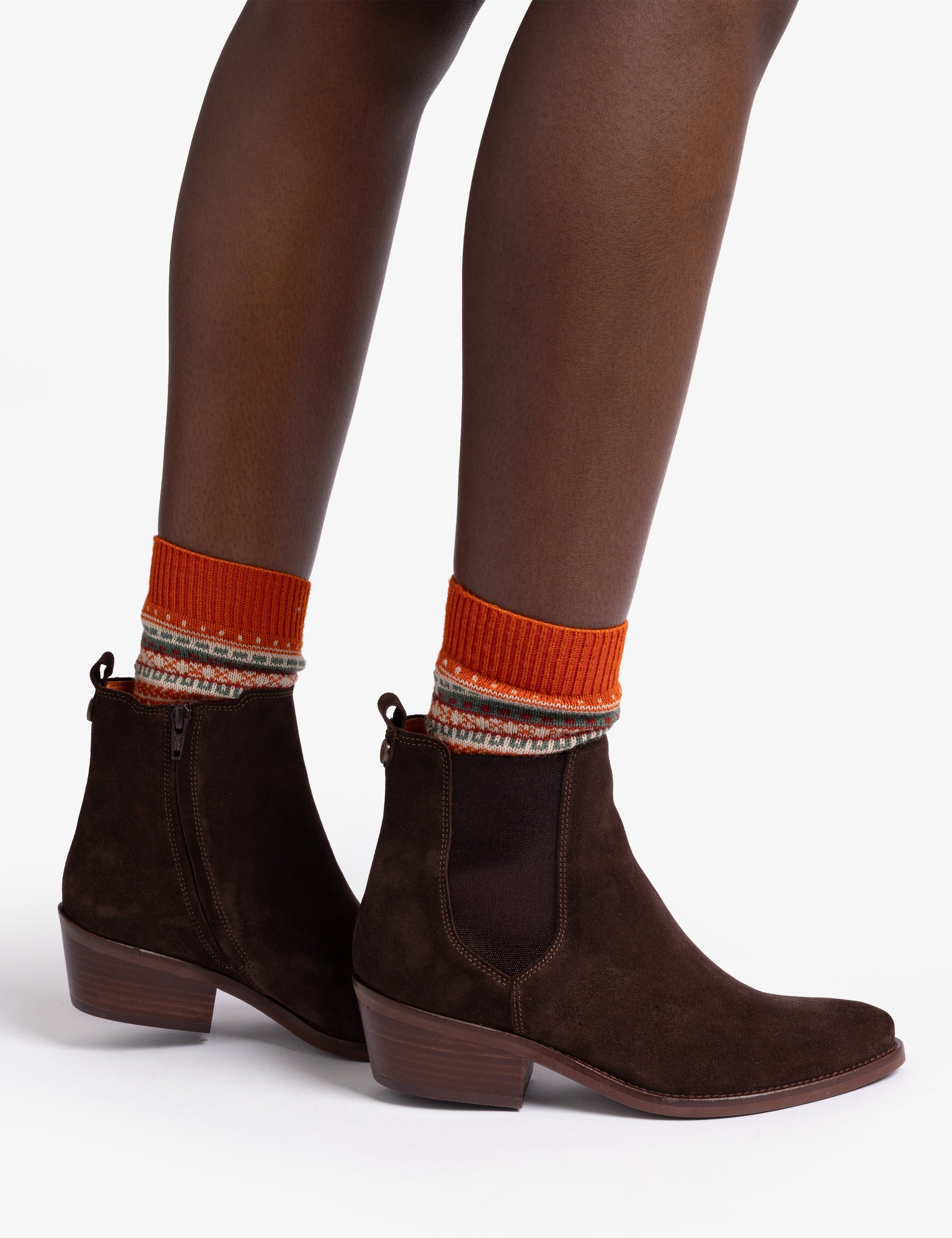 woman wearing Pair of brown suede ankle boots with orange lining on white background