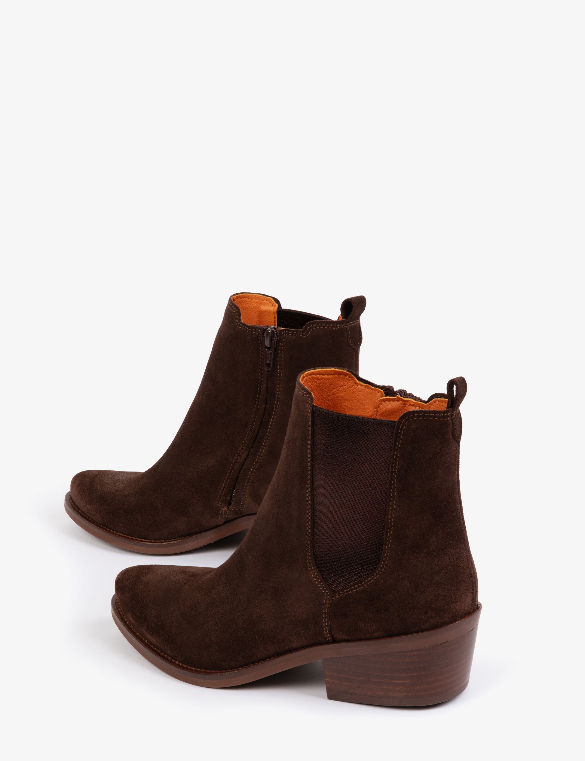 Pair of brown suede ankle boots with orange lining on a white background