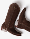 A pair of dark brown suede cowboy boots with a small gold star detail on the shaft, shown from a high-angle studio perspective on a white background.