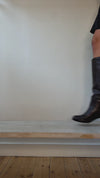 Model wearing heeled pebbled leather brown high boot shown at different angles. 