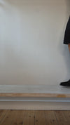 Model wearing  black suede Chelsea-style ankle boots with elastic side panels and low block heels shown at different angles. 
