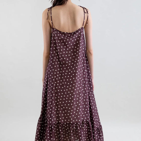 Woman wearing a polka dot dress on a plain background