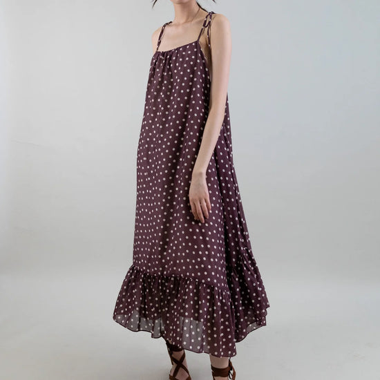 Woman wearing a polka dot dress on a plain background