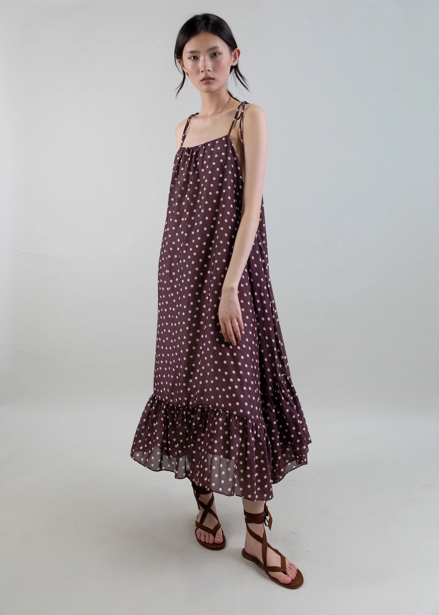 Woman wearing a polka dot dress on a plain background