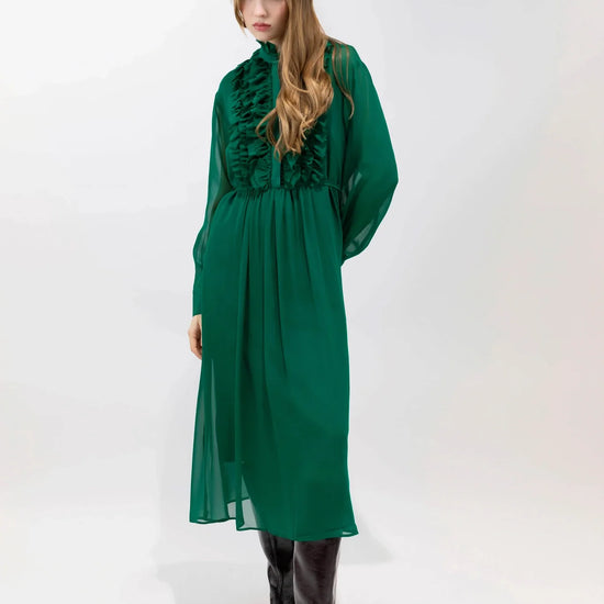 Woman wearing a green dress with ruffled details on a white background