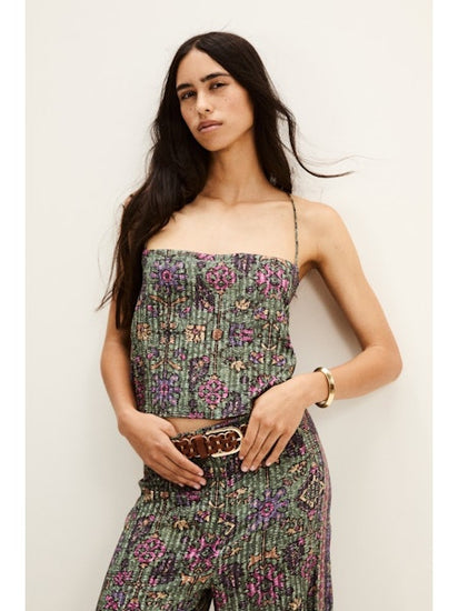 Woman wearing a aztec print top and trousers against a plain background from ba&sh