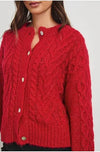 red cable knit cardigan with round neck and long sleeves close up