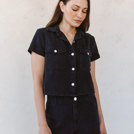woman wearing black denim short sleeve shirt with white background - full outfit