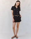 woman wearing black denim short sleeve shirt with white background. -full length