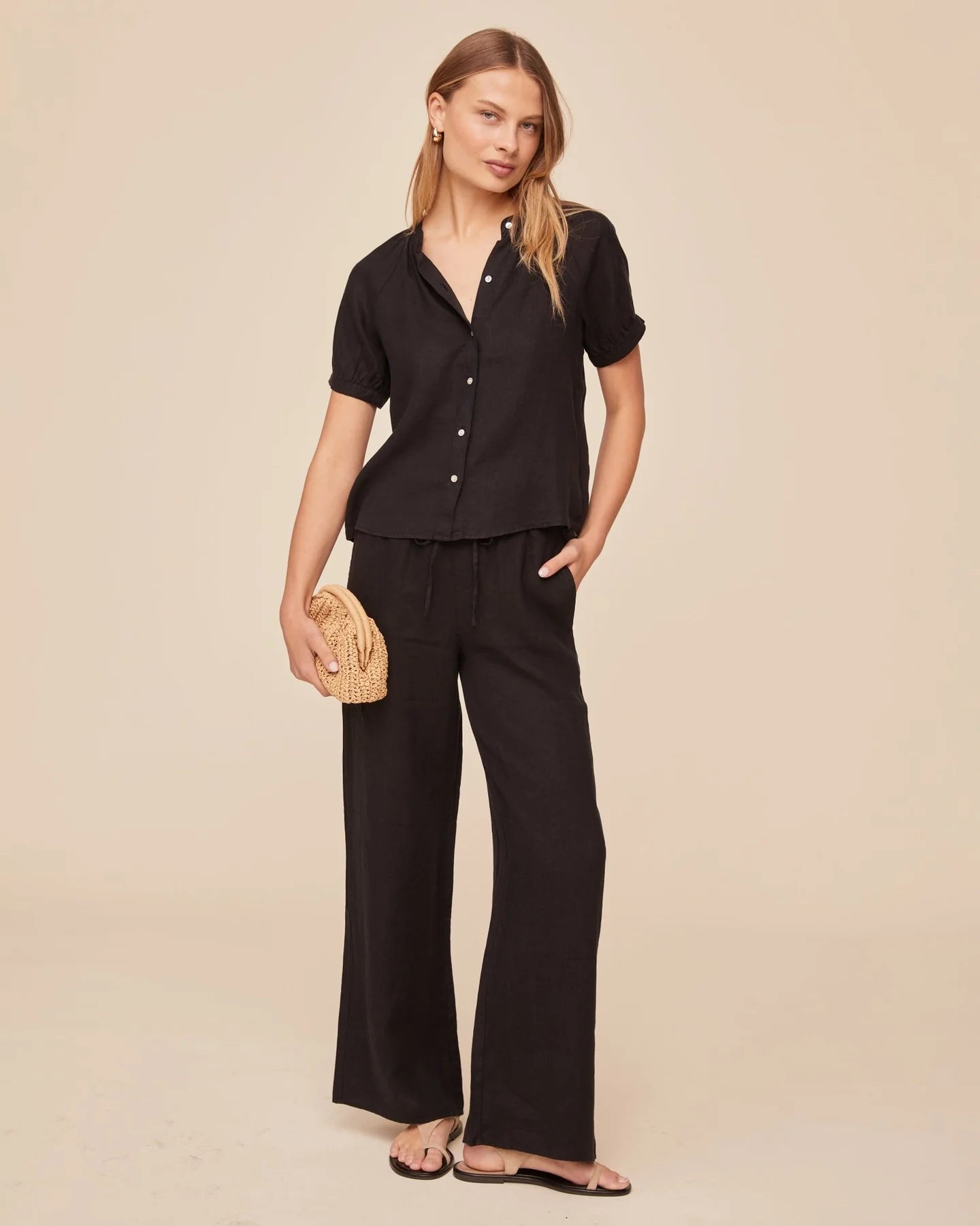 Black short sleeve shirt paired with black wide leg trousers