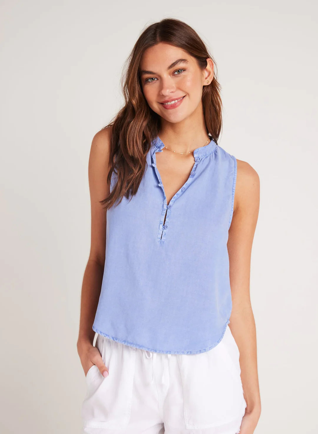 Cornflower blue sleeveless top with stand up collar and edge to edge button fastening