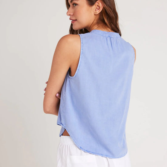 Cornflower blue sleeveless top with stand up collar and edge to edge button fastening