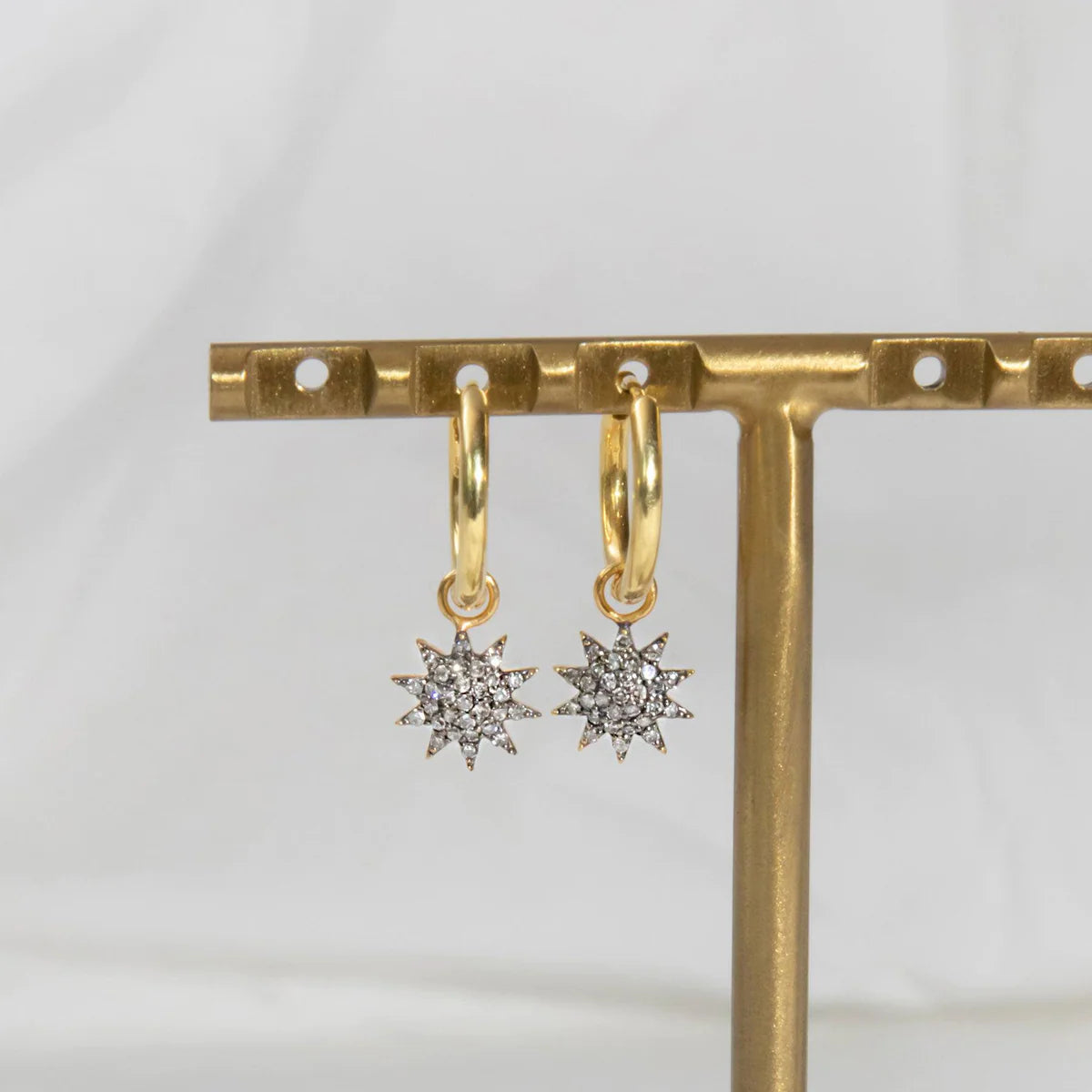 Starburst gold hoop earrings with pave diamonds