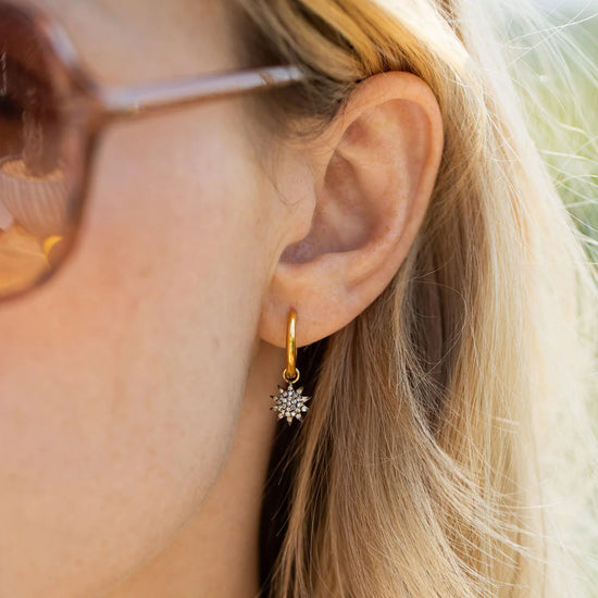 Starburst gold hoop earrings with pave diamonds