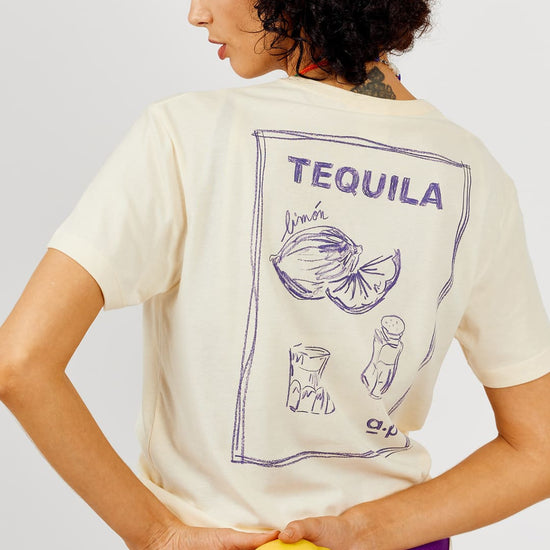 Person wearing a t-shirt with 'Tequila' and lemon graphic, holding a lemon.