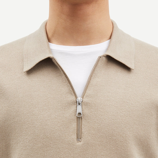 beige half zip polo jumper with classic collar and long sleeves close up