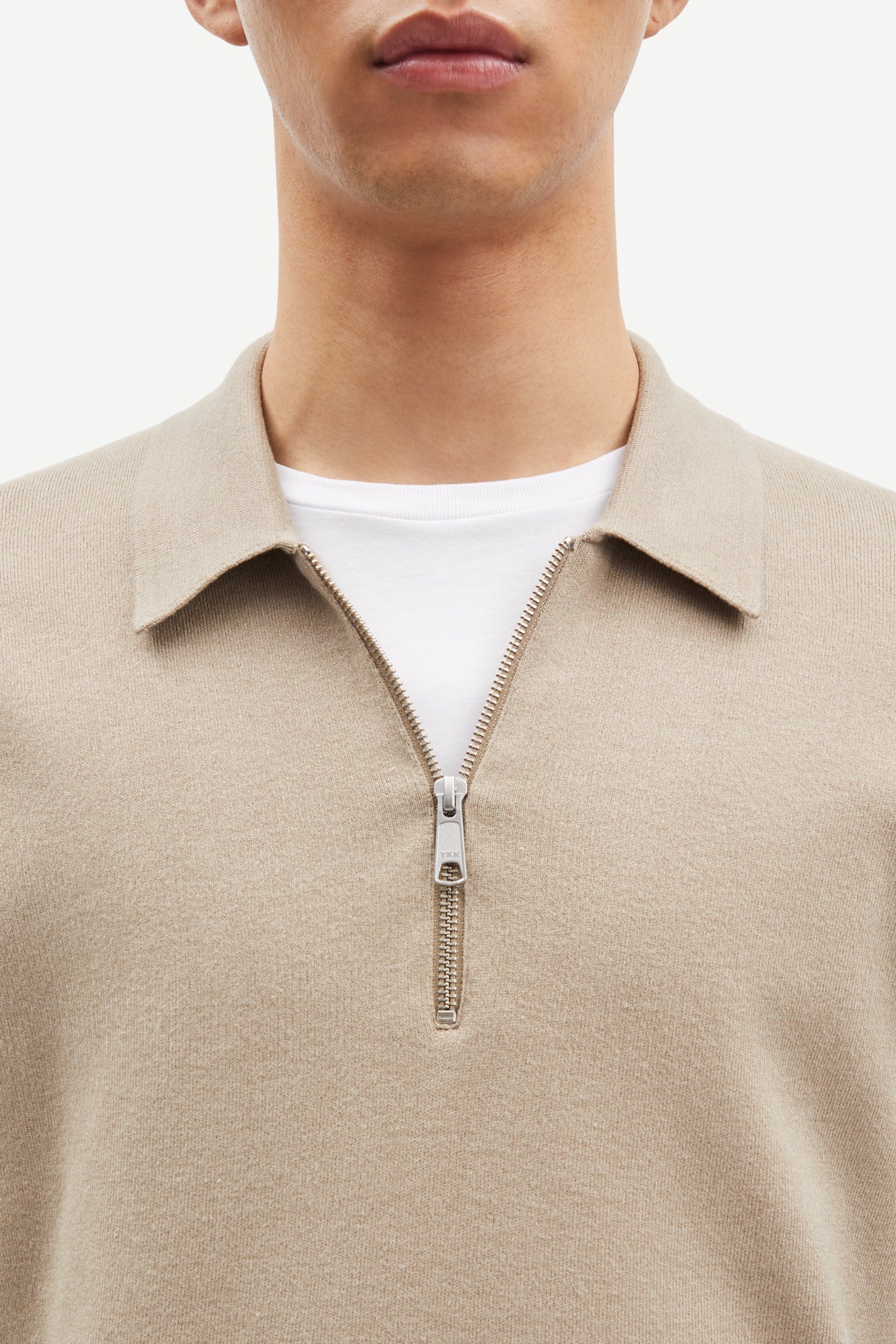 beige half zip polo jumper with classic collar and long sleeves close up