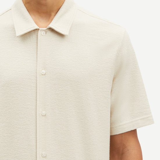 oatmeal short sleeved shirt with point collar in a slubbed textured material close up