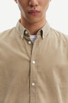 light brown baby cord button down shirt with single button cuff and curved hem close up