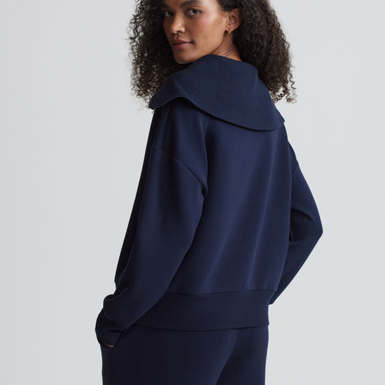 Rear view of navy half zip on model