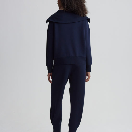 Rear view of navy sweat worn with matching bottoms