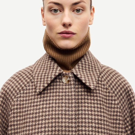 oversized brown check winter coat with wide sleeves with belted cuffs and concealed placket  close up
