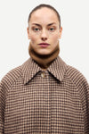 oversized brown check winter coat with wide sleeves with belted cuffs and concealed placket  close up