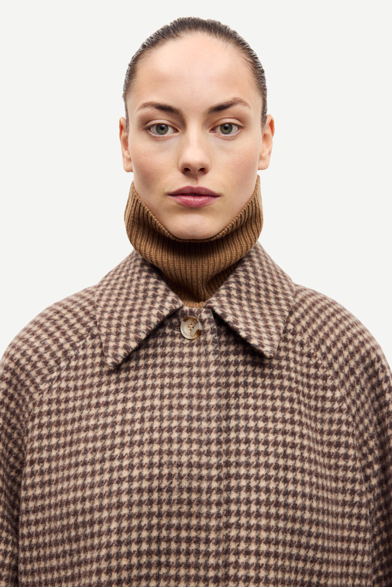 oversized brown check winter coat with wide sleeves with belted cuffs and concealed placket  close up