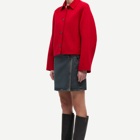 red boxy wool jacket with classic collar, black buttons and slightly cropped fit side view 
