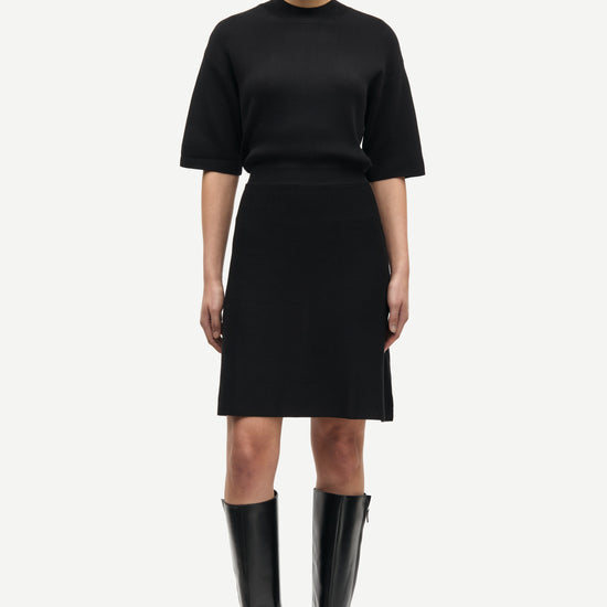 black short dress with flutter sleeves and waterfall skirt model shot