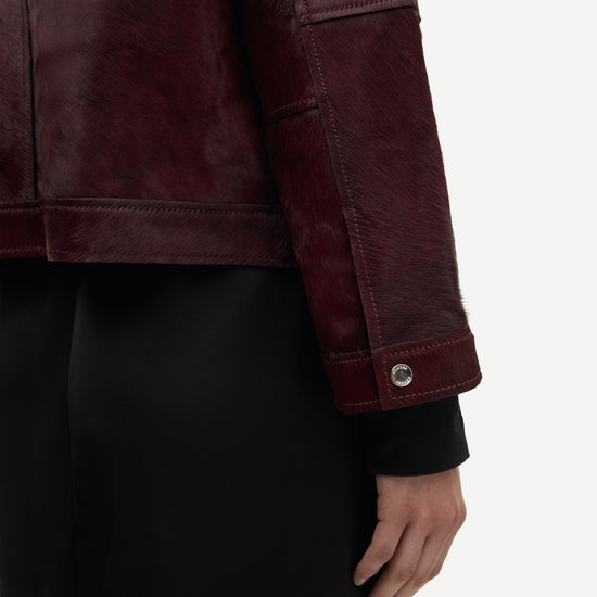 brown leather jacket with buckle at the neck and boxy fit close up