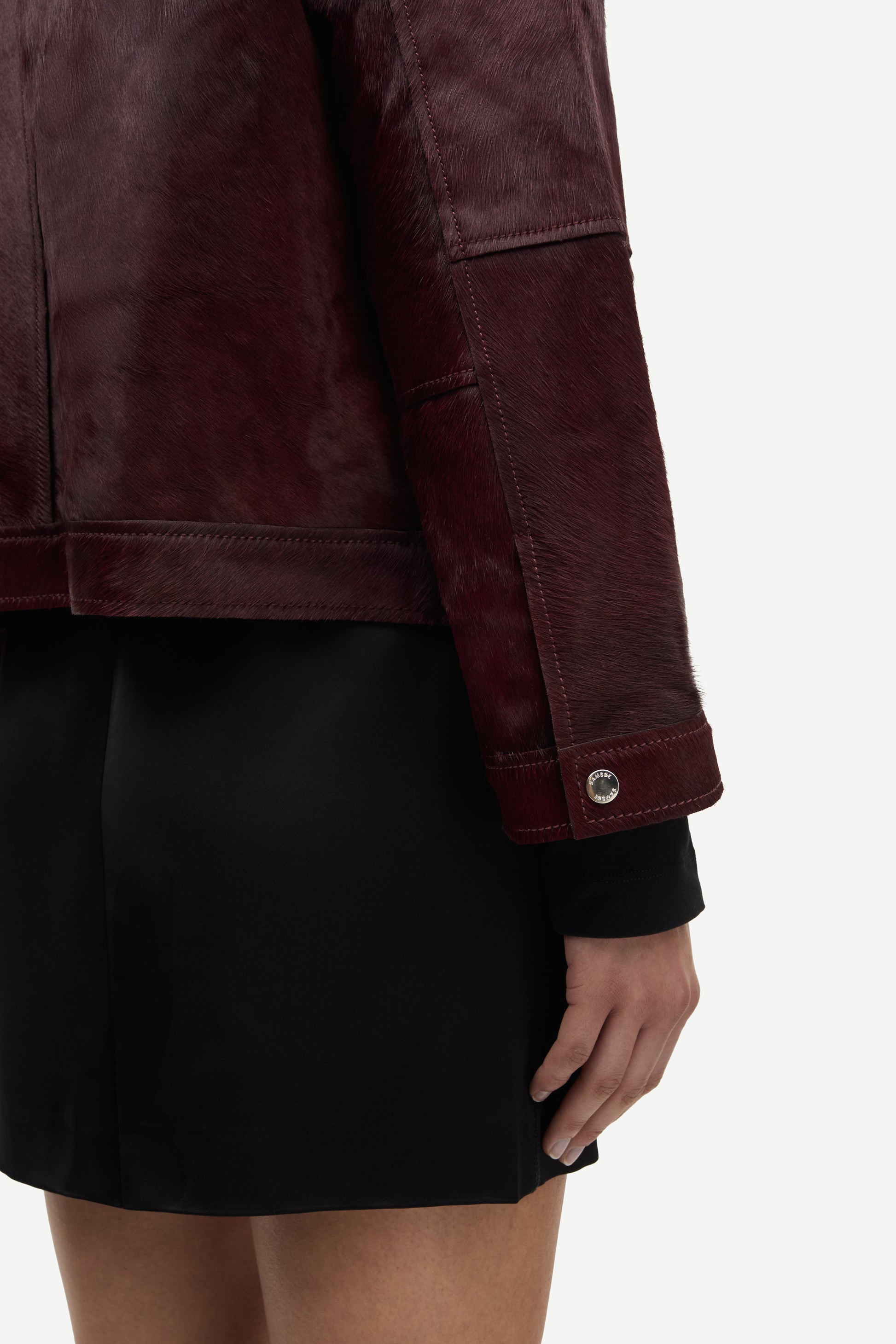 brown leather jacket with buckle at the neck and boxy fit close up