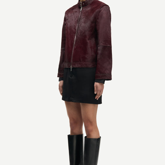 brown leather jacket with buckle at the neck and boxy fit side view 