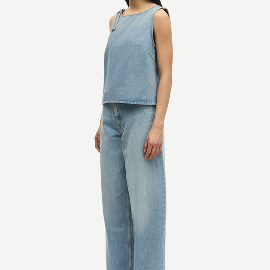 blue cotton tank top with belt detail on one shoulder and cut in a denim style model shot side view