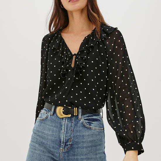 V neck black top with ruffled neck and polka dots model shot