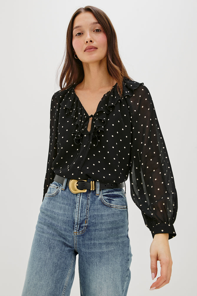 V neck black top with ruffled neck and polka dots model shot