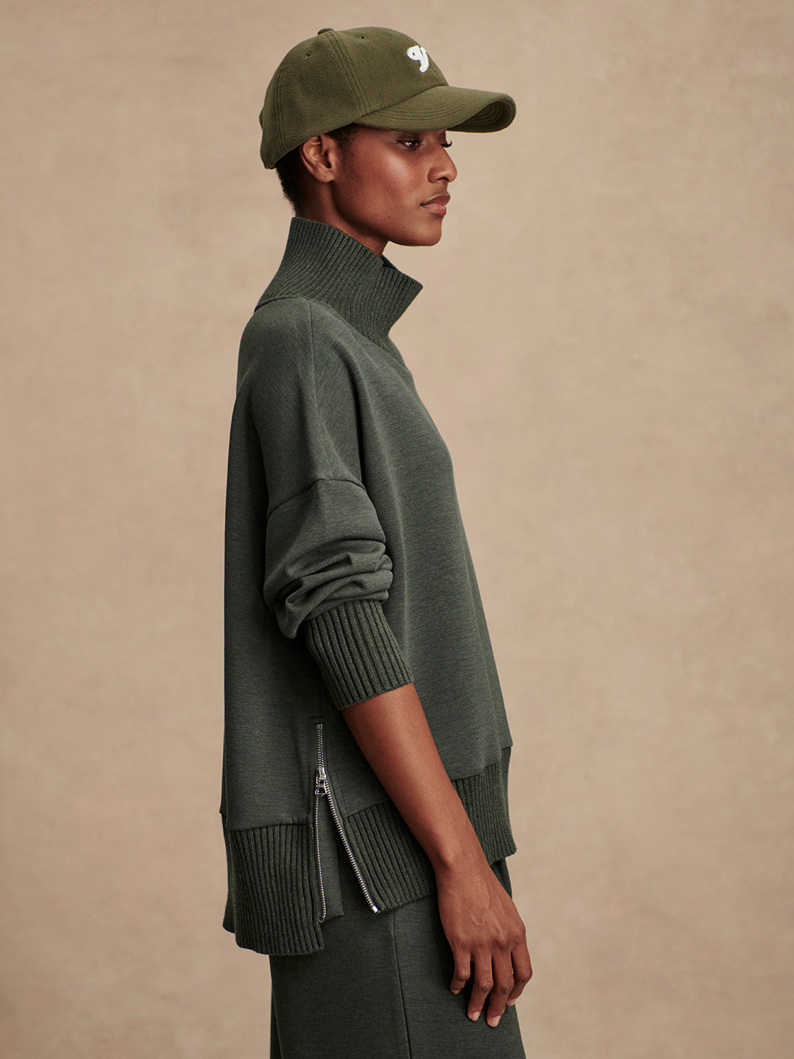 Olive green jumper with rib detailing and side zip side view