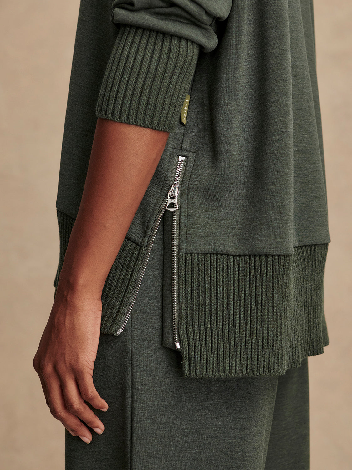 Olive green jumper with rib detailing and side zip close up