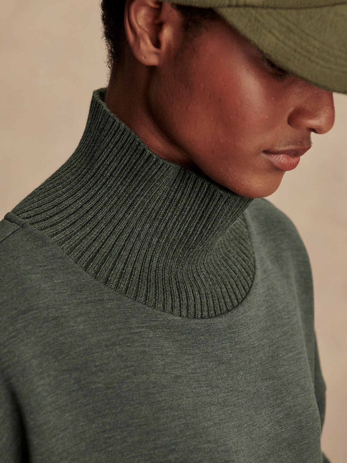Olive green jumper with rib detailing and side zip close up