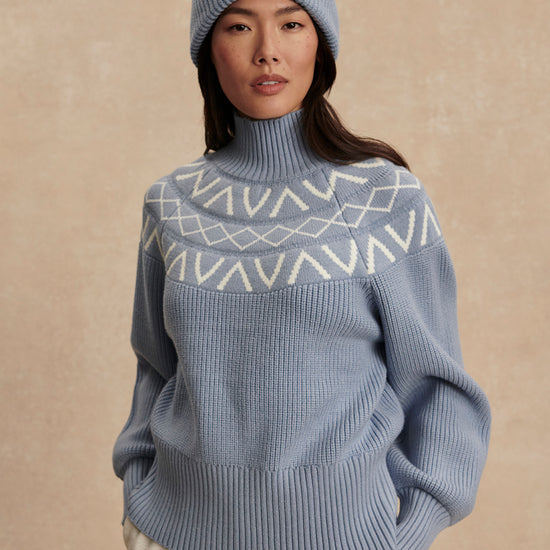 blue ribbed jumper with white varley logo and high neck